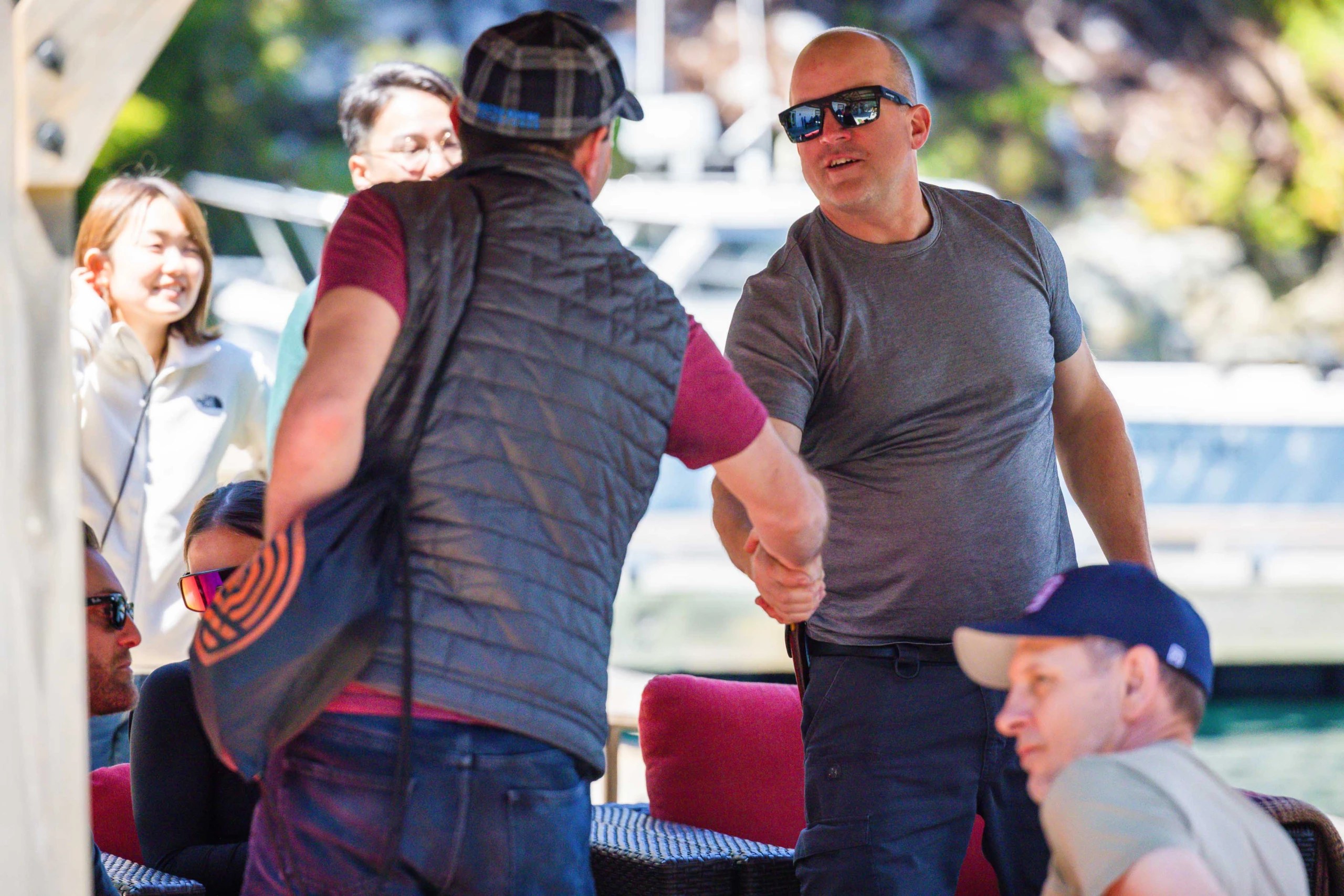 Two men shake hands as they meet dockside